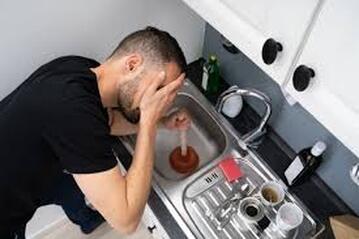 frustrated man with clogged sink